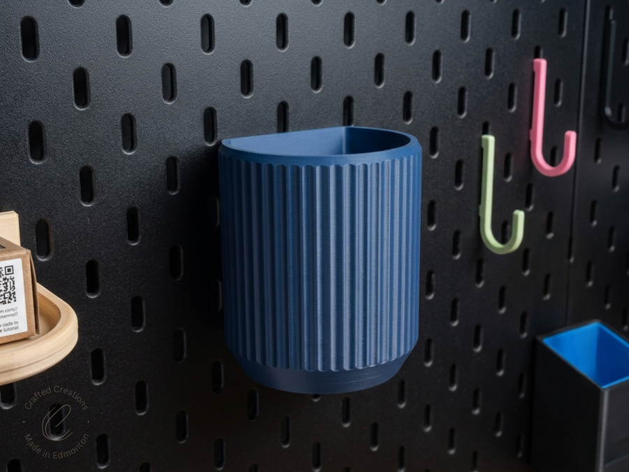 Blue fluted holder mounted on a black SKÅDIS pegboard